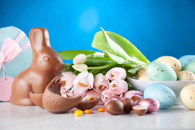 White Flowers Between Brown Rabbit Figure and Eggs